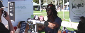 Image of stallholder pouring Kombucha at Summer Salt Markets